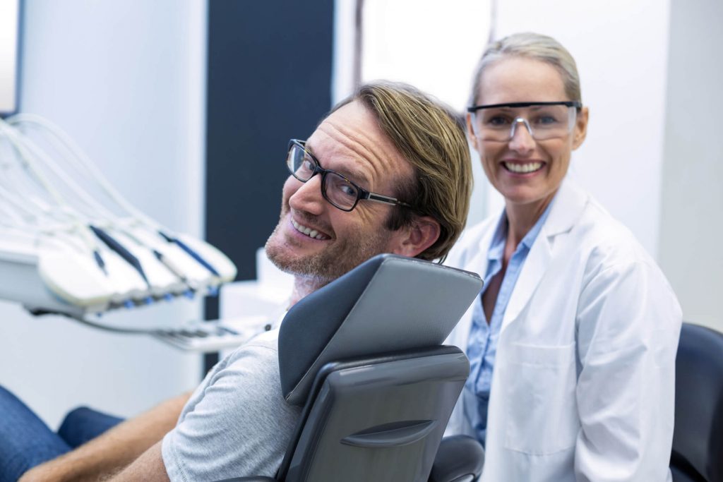 dentist and patient smiling prior to an oral surgery in Greenville, SC