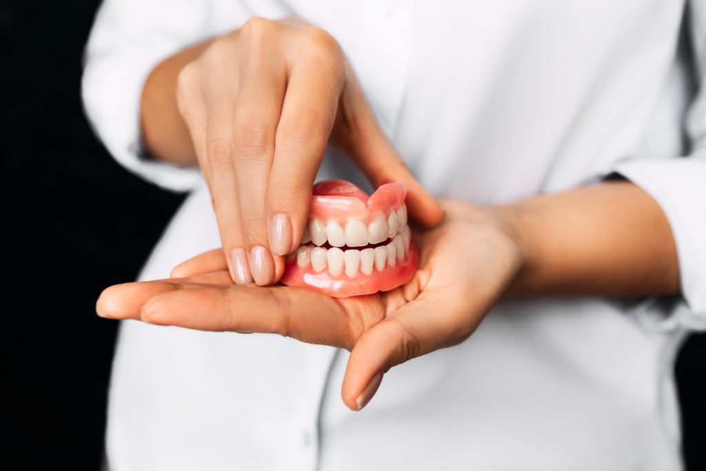 dentist holding dentures in Greenville SC