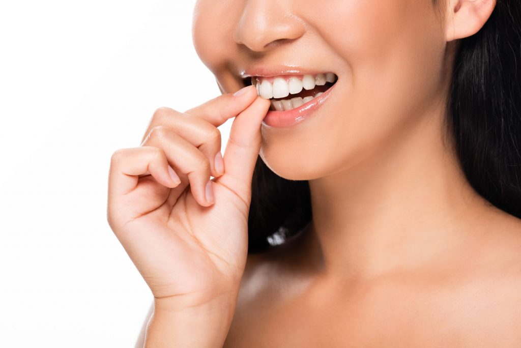 woman grabbing her teeth with veneers in Simpsonville SC